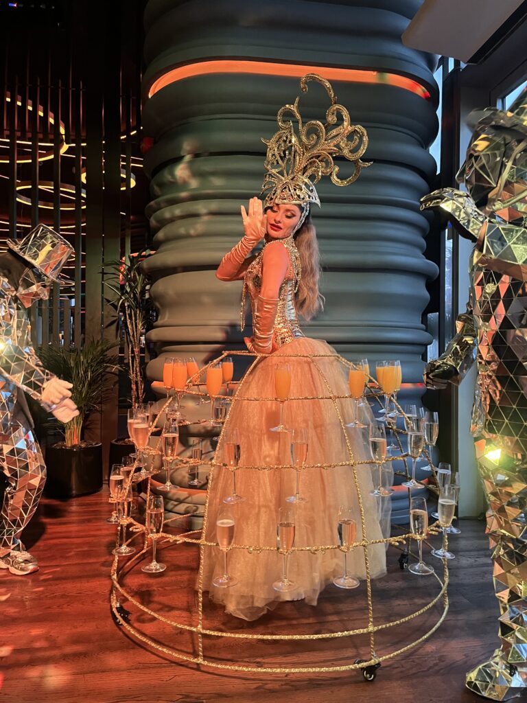 Futuristic mirror dancers performing at a private VIP event in Dubai with reflected lights and skyline background.