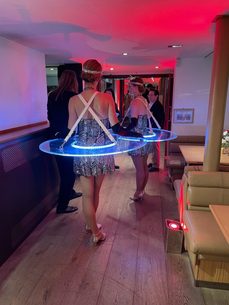 Zancudos elegantes y mesas vivientes recibiendo a invitados en una boda exclusiva.